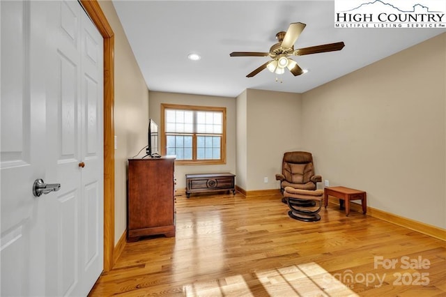 living area with light hardwood / wood-style floors and ceiling fan