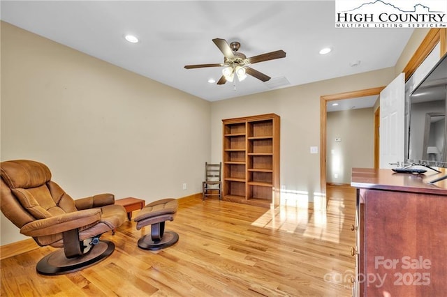 living area with light hardwood / wood-style flooring and ceiling fan