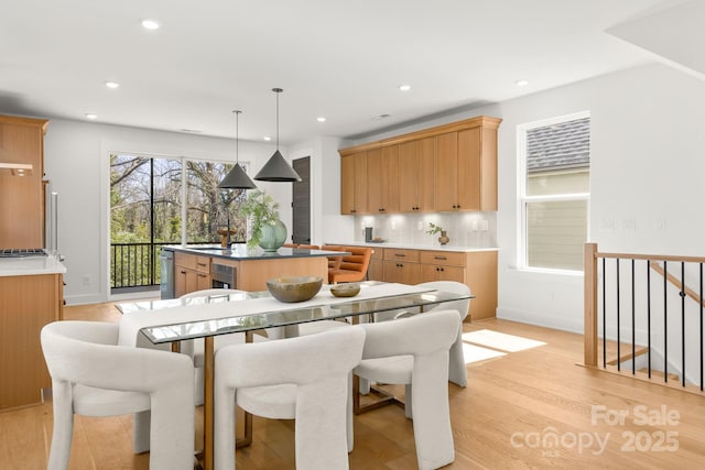 dining area with baseboards, recessed lighting, and light wood-style floors