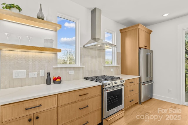 kitchen with wall chimney range hood, appliances with stainless steel finishes, light wood-type flooring, open shelves, and tasteful backsplash