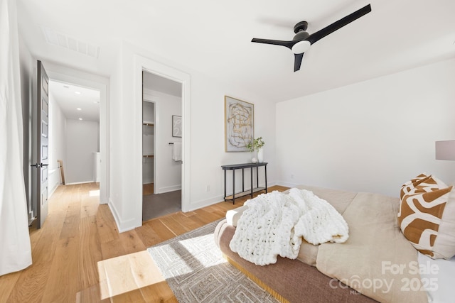 bedroom with visible vents, a spacious closet, light wood-style floors, ceiling fan, and baseboards