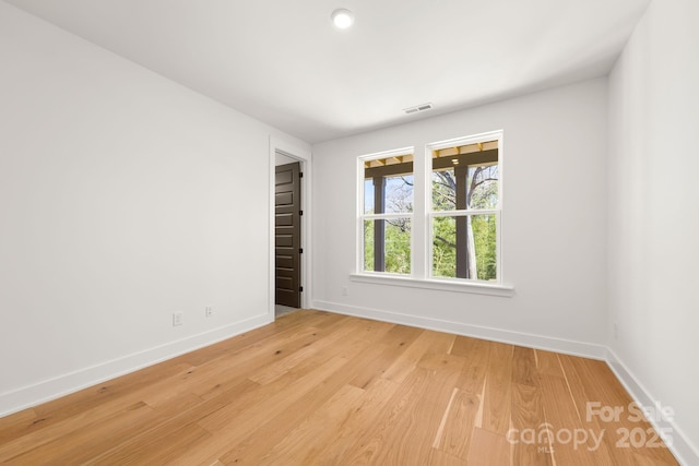 unfurnished room with light wood-type flooring, baseboards, and visible vents