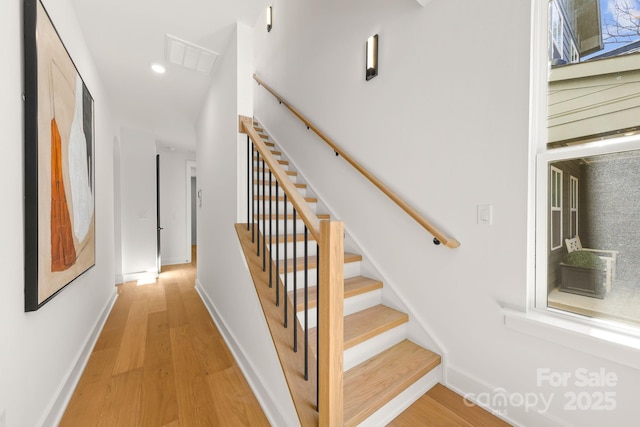 stairway featuring recessed lighting, visible vents, baseboards, and wood finished floors