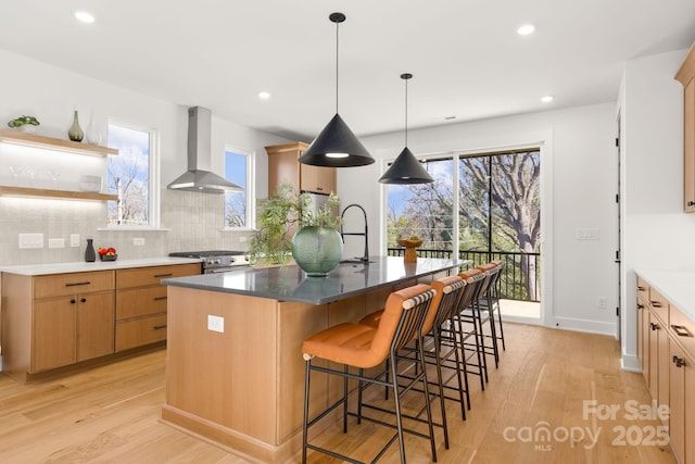 3132 Carol Ave, Charlotte, NC 28208 - kitchen featuring wall chimney exhaust hood, stainless steel range with gas stovetop, light wood-type flooring, backsplash, and recessed lighting