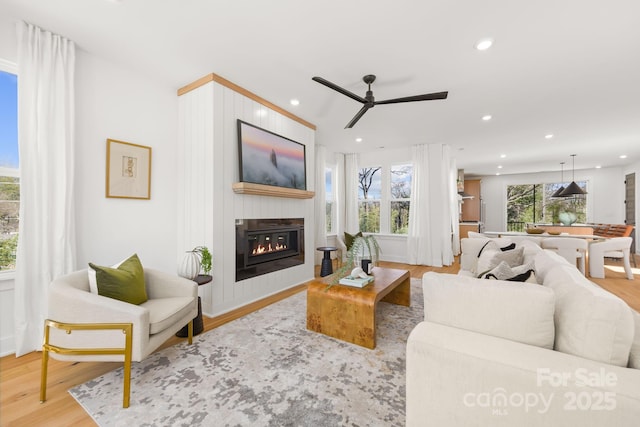 3132 Carol Ave, Charlotte, NC 28208 - living area with a glass covered fireplace, wood finished floors, ceiling fan, and recessed lighting