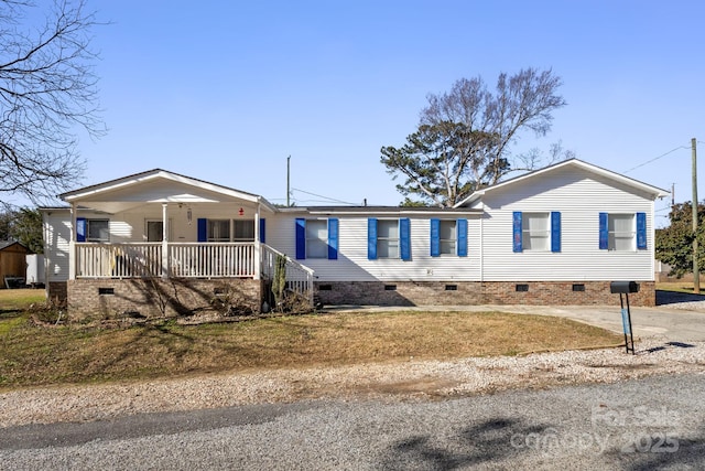 manufactured / mobile home featuring covered porch and a front lawn