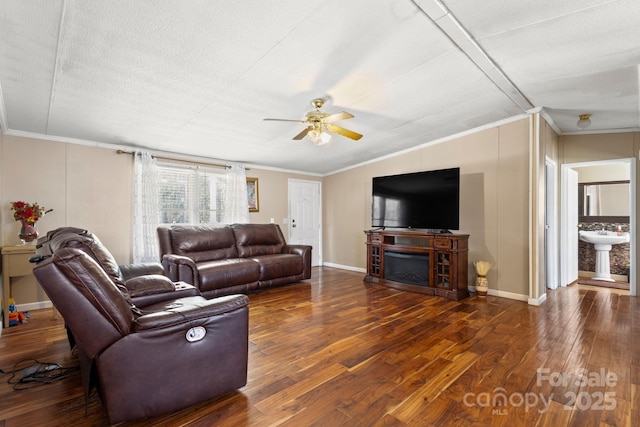 living room with ornamental molding, dark wood-type flooring, and sink