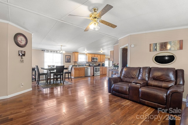 living room featuring crown molding, dark wood-type flooring, ceiling fan with notable chandelier, and vaulted ceiling