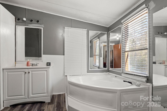 bathroom featuring crown molding, vanity, a bathing tub, and hardwood / wood-style floors