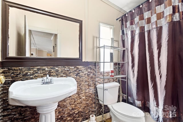 bathroom with sink, tile walls, ornamental molding, walk in shower, and toilet