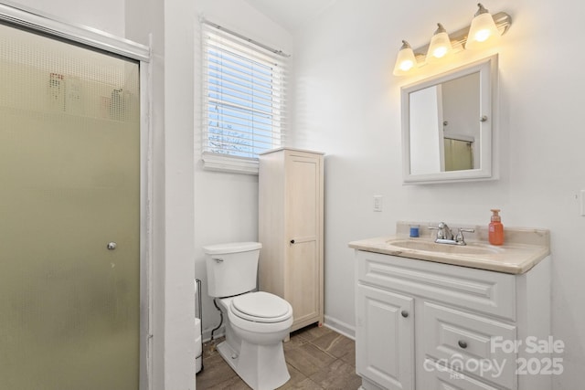 bathroom featuring vanity, walk in shower, and toilet