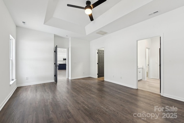 interior space featuring ceiling fan, dark hardwood / wood-style flooring, and a tray ceiling