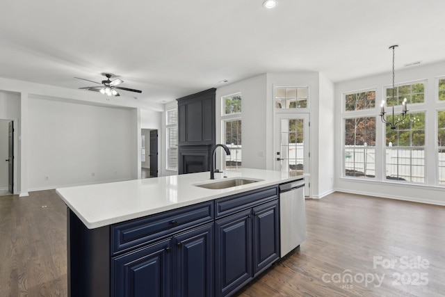 kitchen featuring blue cabinets, sink, a center island with sink, dishwasher, and pendant lighting