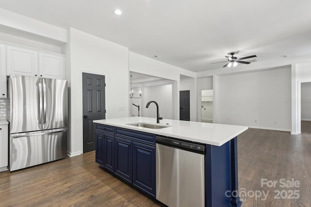 kitchen featuring blue cabinets, sink, white cabinetry, stainless steel appliances, and a kitchen island with sink