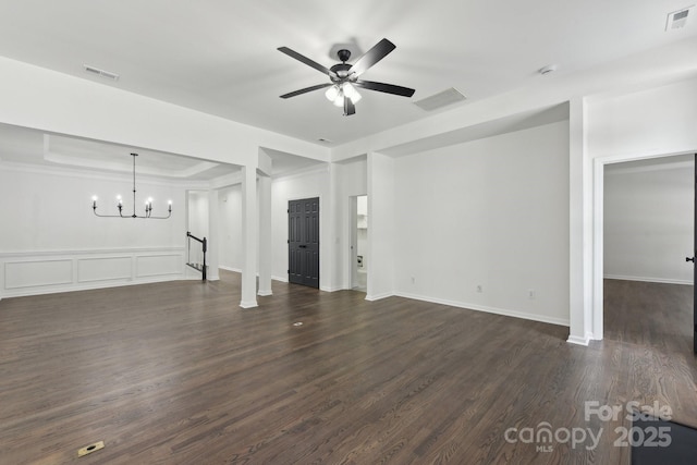 unfurnished living room featuring ceiling fan with notable chandelier, dark wood-type flooring, and a raised ceiling