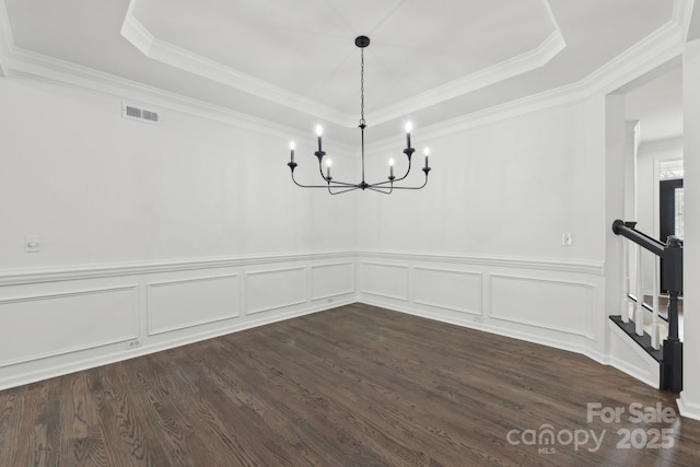 unfurnished dining area featuring an inviting chandelier, a tray ceiling, and dark hardwood / wood-style floors