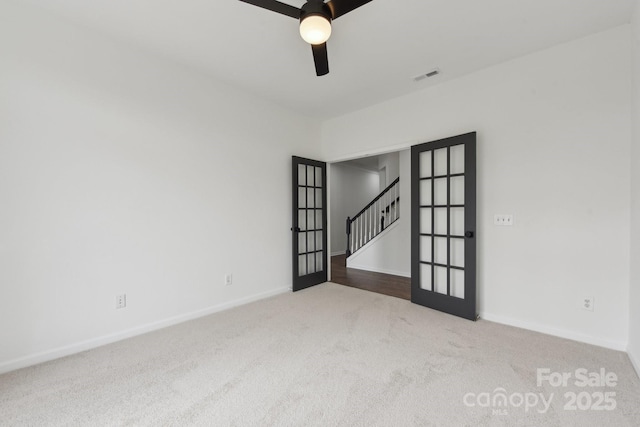 carpeted empty room with ceiling fan and french doors