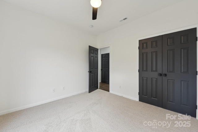 unfurnished bedroom with ceiling fan, a closet, and carpet