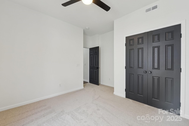 unfurnished bedroom featuring light carpet, ceiling fan, and a closet