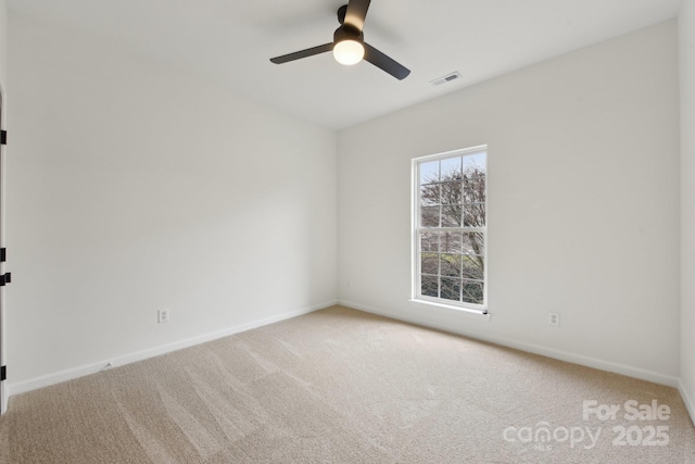 empty room featuring ceiling fan and carpet