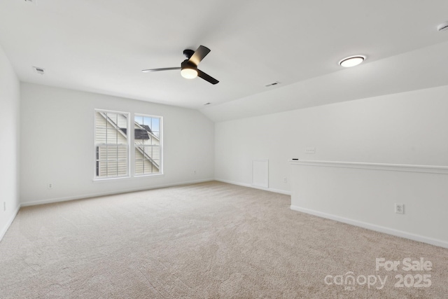 carpeted spare room featuring lofted ceiling and ceiling fan