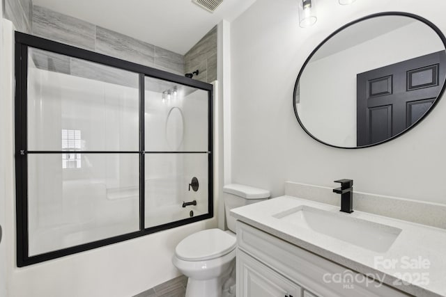 full bathroom featuring enclosed tub / shower combo, vanity, and toilet