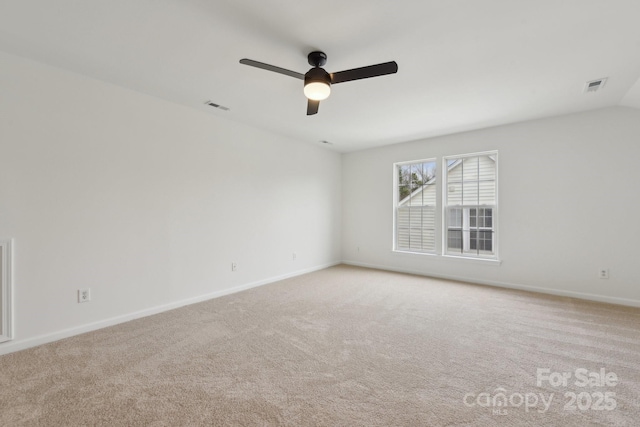 spare room with vaulted ceiling, light carpet, and ceiling fan