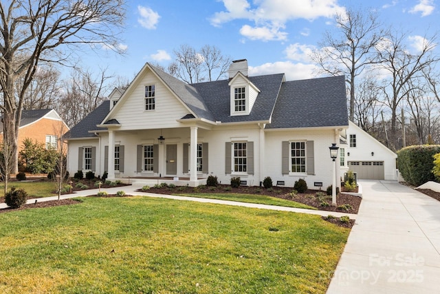 view of front of property featuring a porch, a garage, and a front yard