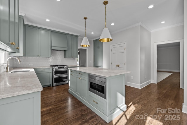 kitchen featuring pendant lighting, sink, premium range hood, stainless steel appliances, and a center island