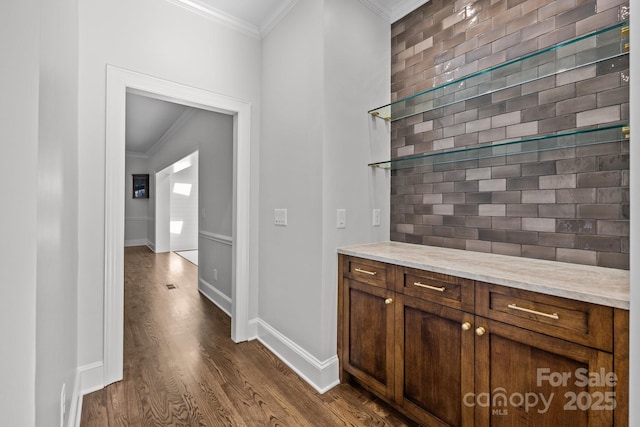 bar featuring light stone countertops, ornamental molding, dark hardwood / wood-style floors, and brick wall