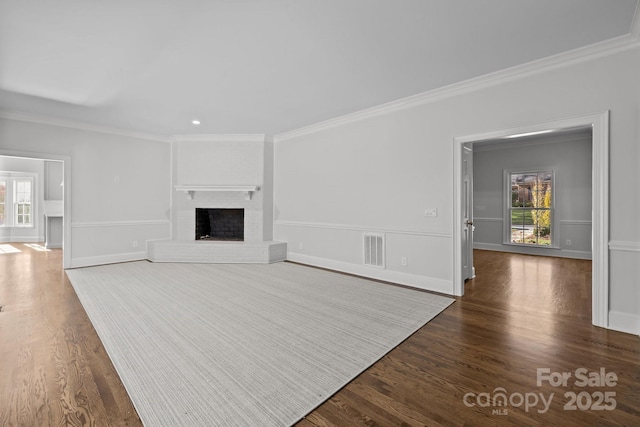 unfurnished living room with ornamental molding, plenty of natural light, a fireplace, and dark hardwood / wood-style flooring