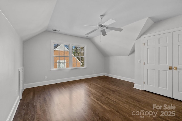 additional living space with dark hardwood / wood-style flooring, vaulted ceiling, and ceiling fan