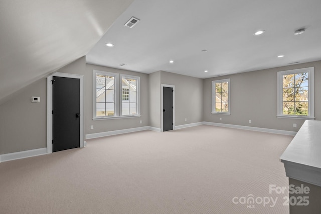 interior space featuring lofted ceiling and light colored carpet