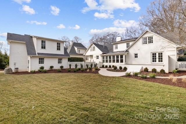 back of house featuring a yard and a sunroom