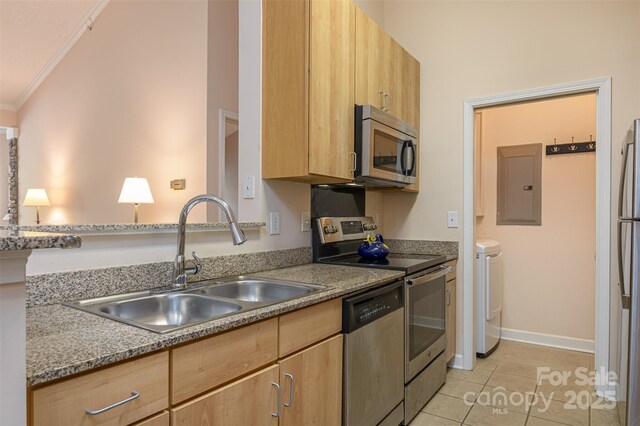 kitchen featuring electric panel, a sink, stainless steel appliances, light brown cabinets, and washing machine and dryer