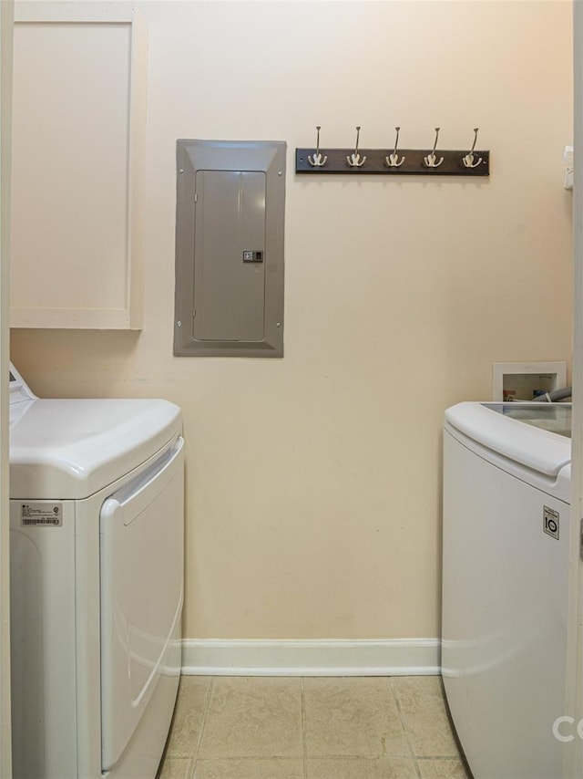 washroom with light tile patterned floors, baseboards, washing machine and dryer, and electric panel