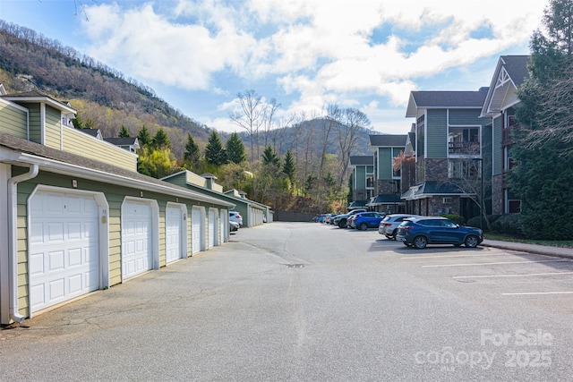 view of road with community garages and a mountain view