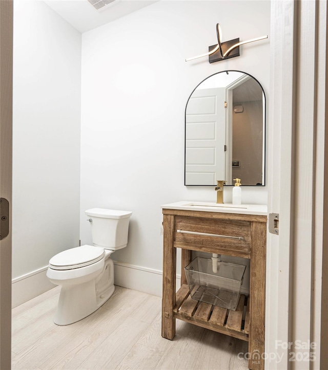 bathroom with vanity, hardwood / wood-style floors, and toilet