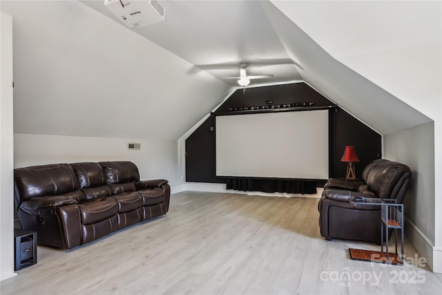 home theater room featuring light hardwood / wood-style flooring, ceiling fan, and vaulted ceiling