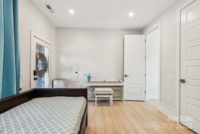 bedroom with electric panel and light hardwood / wood-style flooring