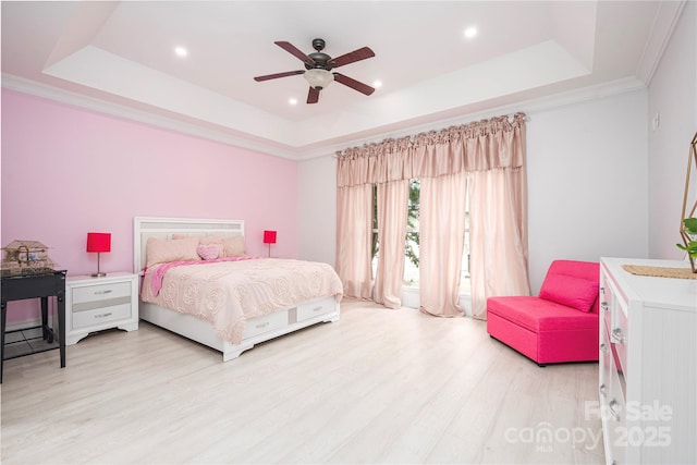 bedroom featuring a raised ceiling, crown molding, ceiling fan, and light wood-type flooring