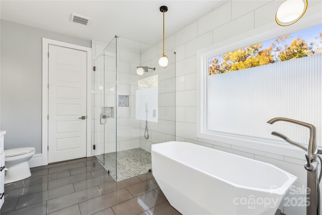 bathroom featuring toilet, separate shower and tub, tile patterned flooring, and tile walls