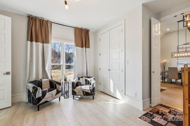 living area featuring light hardwood / wood-style floors and a chandelier