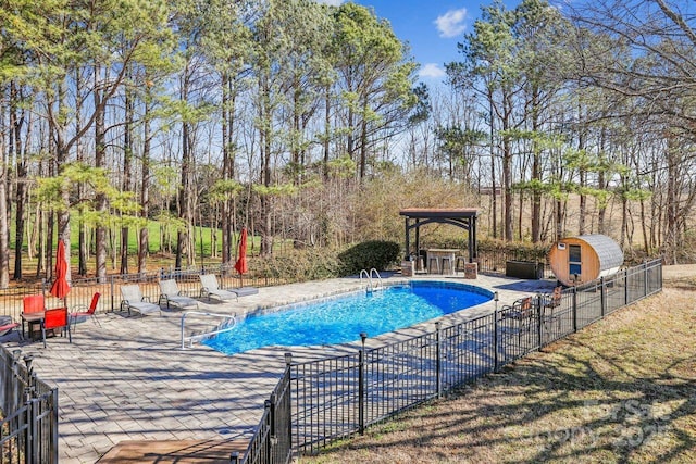 view of pool featuring a gazebo, a storage unit, and a patio