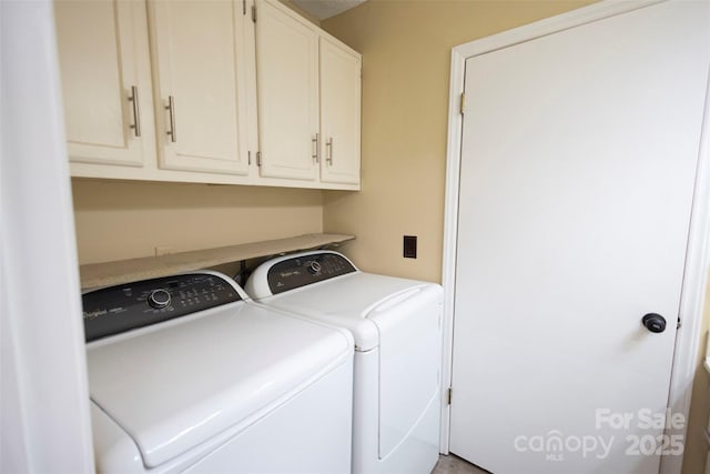 clothes washing area featuring cabinets and washing machine and clothes dryer