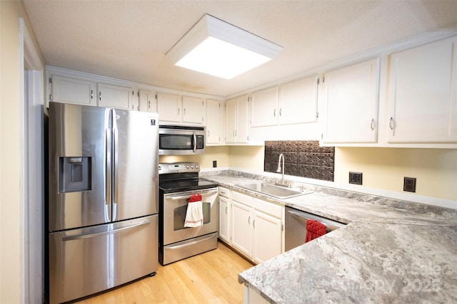 kitchen featuring white cabinetry, appliances with stainless steel finishes, sink, and light wood-type flooring