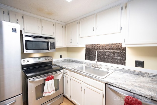 kitchen featuring stainless steel appliances, sink, a textured ceiling, and white cabinets