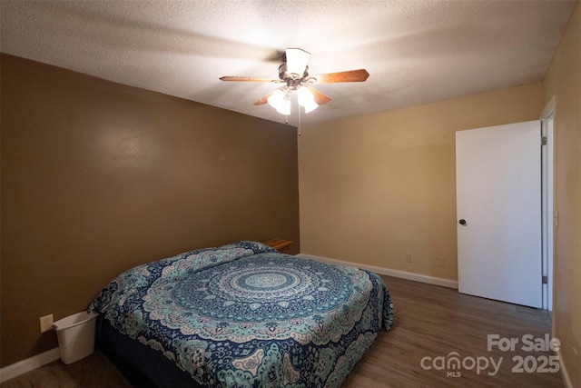 bedroom featuring ceiling fan, wood-type flooring, and a textured ceiling