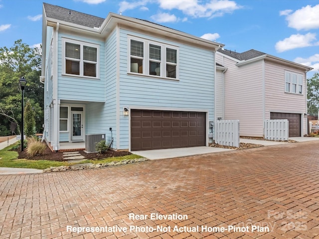 view of front of property featuring a garage and central AC