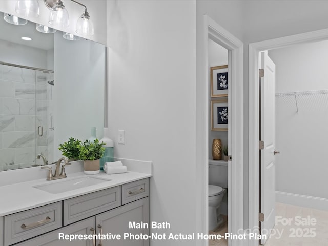 bathroom with vanity, a shower with shower door, and toilet